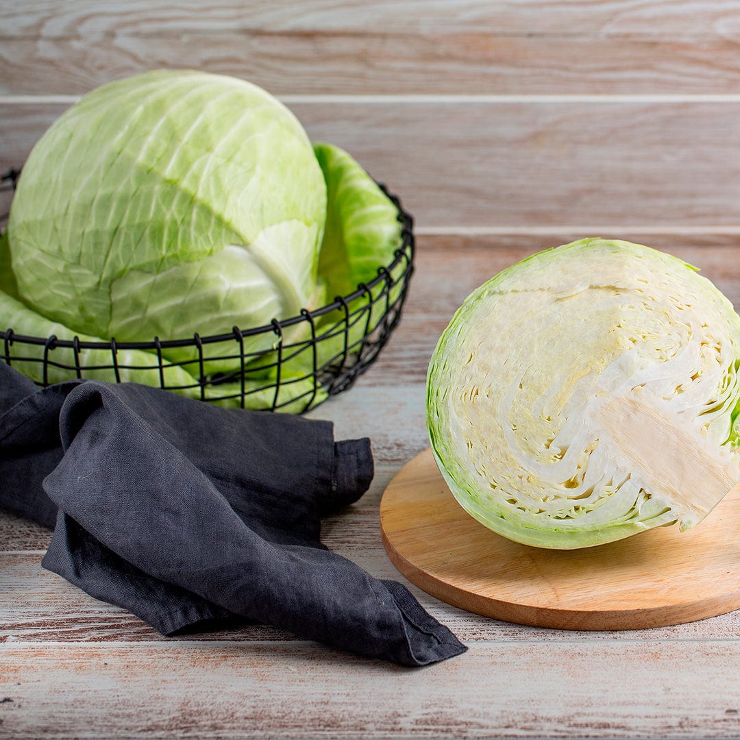 Round green cabbage heads with crisp leaves, one whole in a wire basket and one half cut on a wooden board. - Organic Cabbage Seeds — 'Golden Acre' - Default Title - Back to the Roots