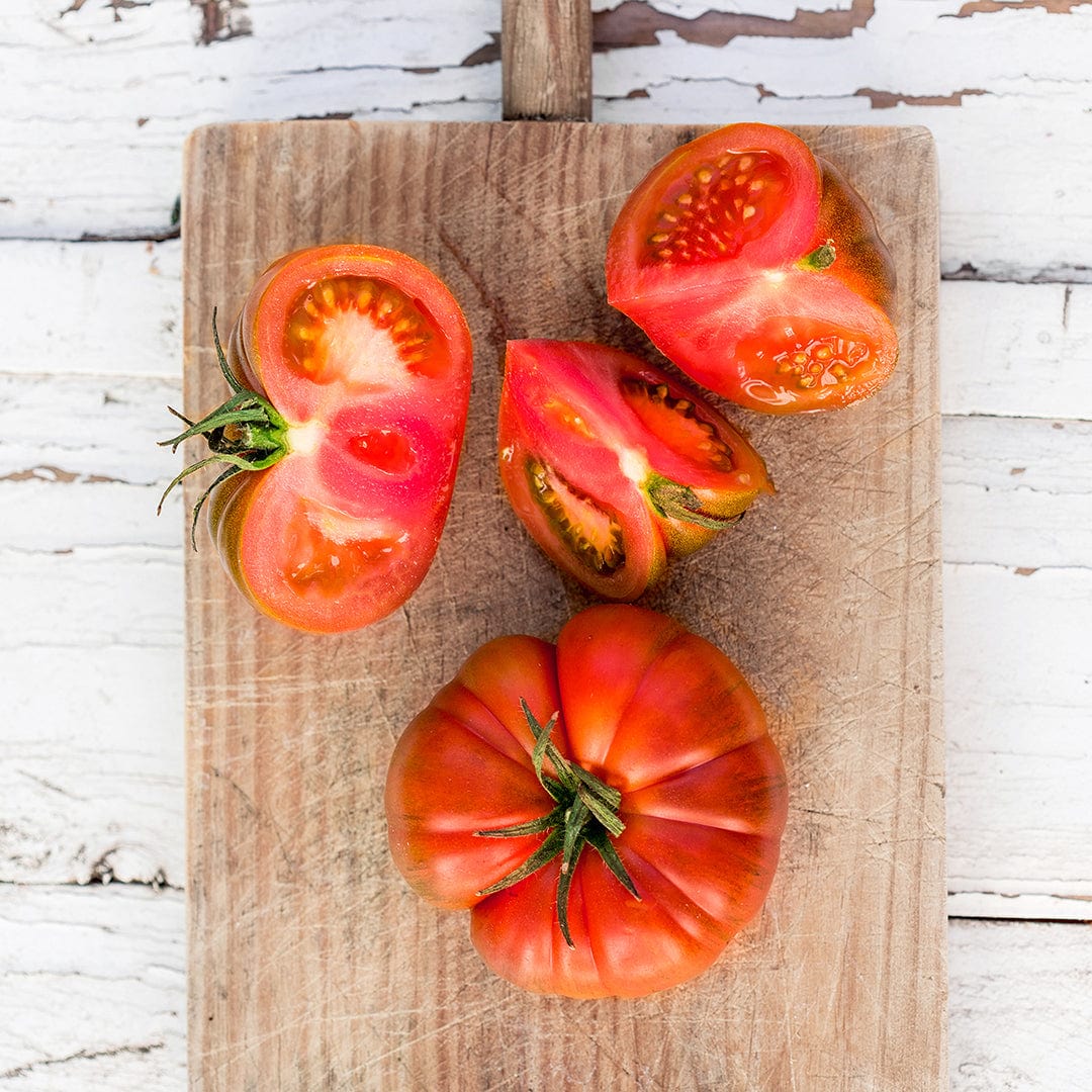 Heirloom beefsteak tomato whole and three halves on rustic wooden board. - Organic Tomato Seeds — 'Beefsteak' - Default Title - Back to the Roots