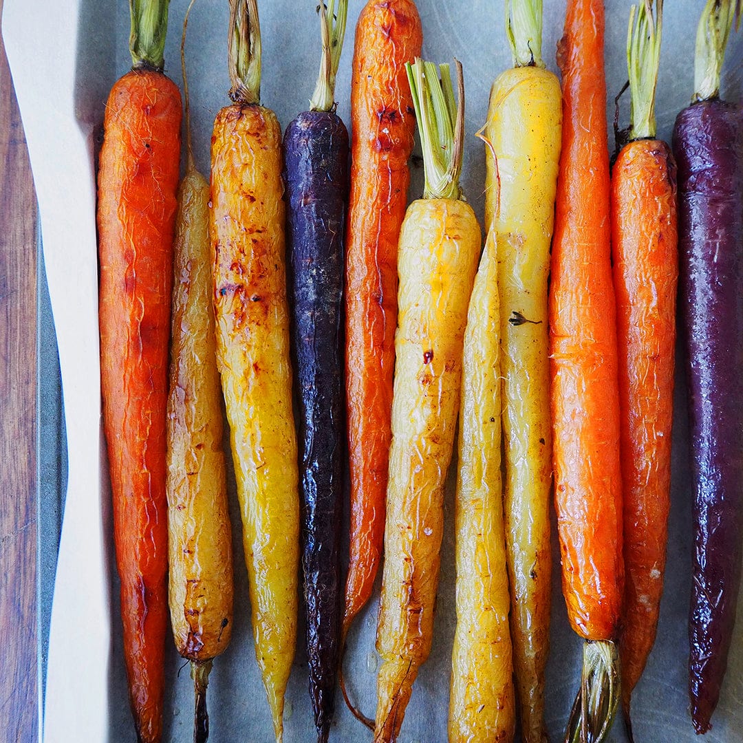 Back to the Roots' Organic Carrot Seeds — 'Rainbow Blend' grow vibrant orange, yellow, and purple carrots—perfect for arranging fresh garden-roasted vegetables on a parchment-lined baking sheet.