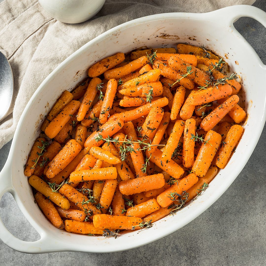 Roasted baby carrots seasoned with herbs in a white oval ceramic baking dish. - Organic Carrot Seeds — 'Baby Bambino' - Default Title - Back to the Roots