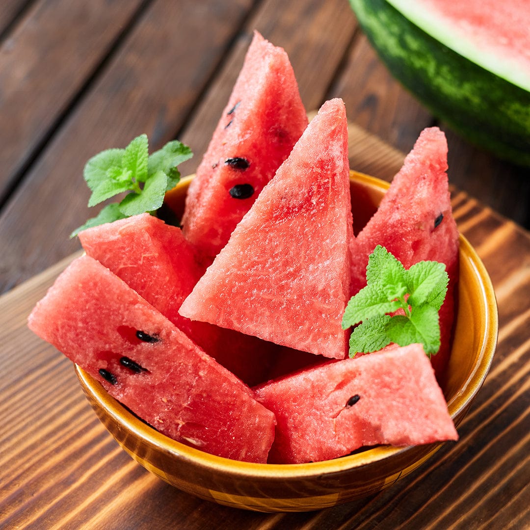 Bowl of juicy red watermelon slices with black seeds garnished with fresh green mint leaves on wooden surface. - Organic Watermelon Seeds — 'Crimson Sweet' - Default Title - Back to the Roots