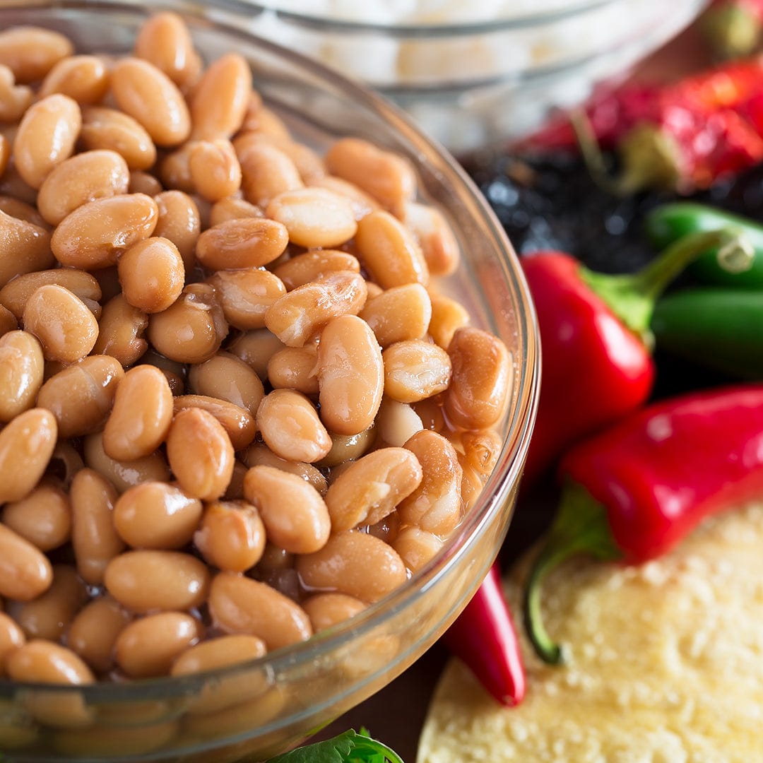 Glass bowl filled with light brown organic pinto beans with chili peppers and tortilla chips in the background. - Organic Bean Seeds — 'Pinto' - Default Title - Back to the Roots