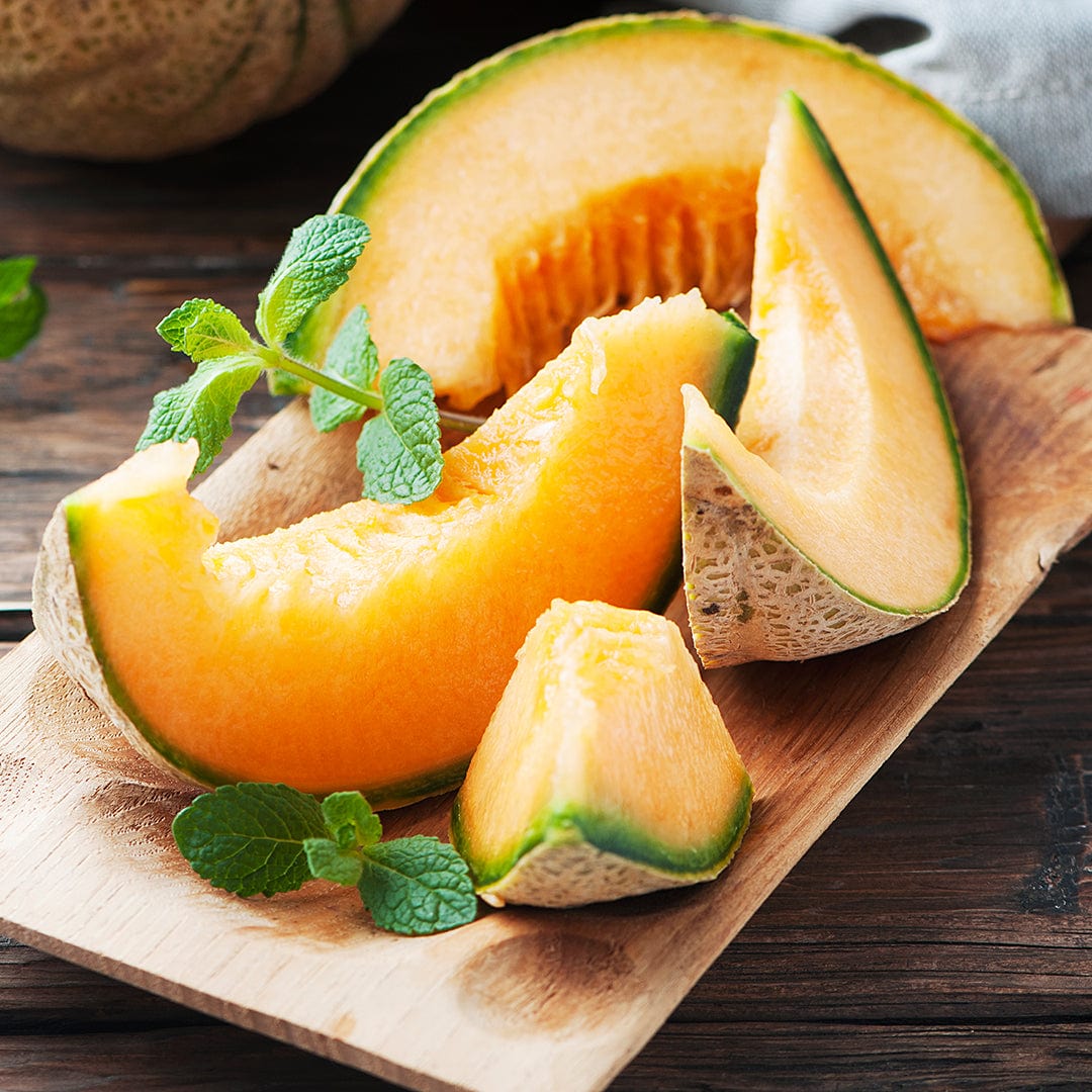 Slices of ripe orange cantaloupe melon with green rind on a wooden board with fresh mint leaves. - Organic Cantaloupe Seeds — 'Hale's Best Jumbo Melon' - Default Title - Back to the Roots