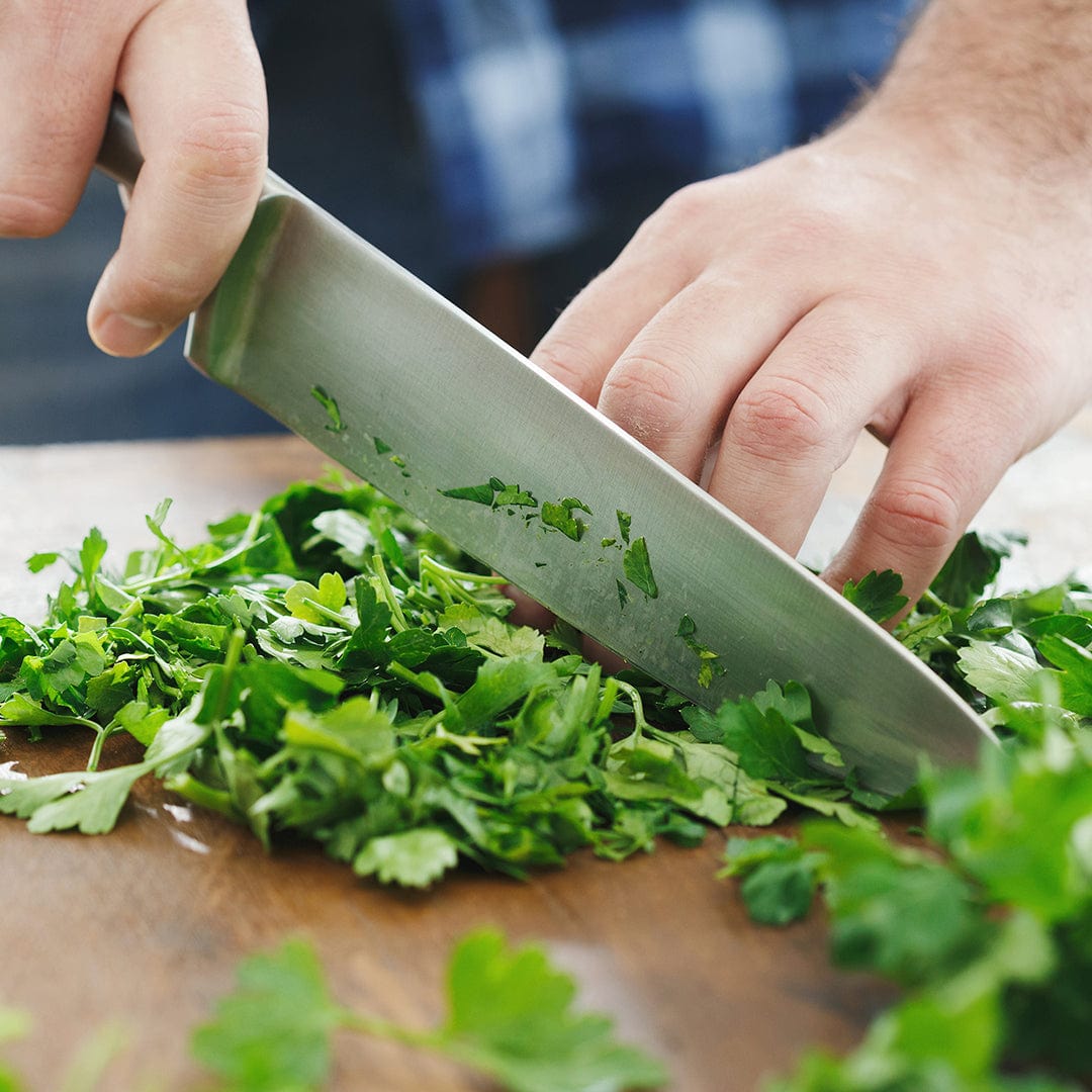 Hands chopping fresh large leaf Italian parsley on wooden cutting board with chef’s knife. - Organic Parsley Seeds — 'Italian Large Leaf' - Default Title - Back to the Roots