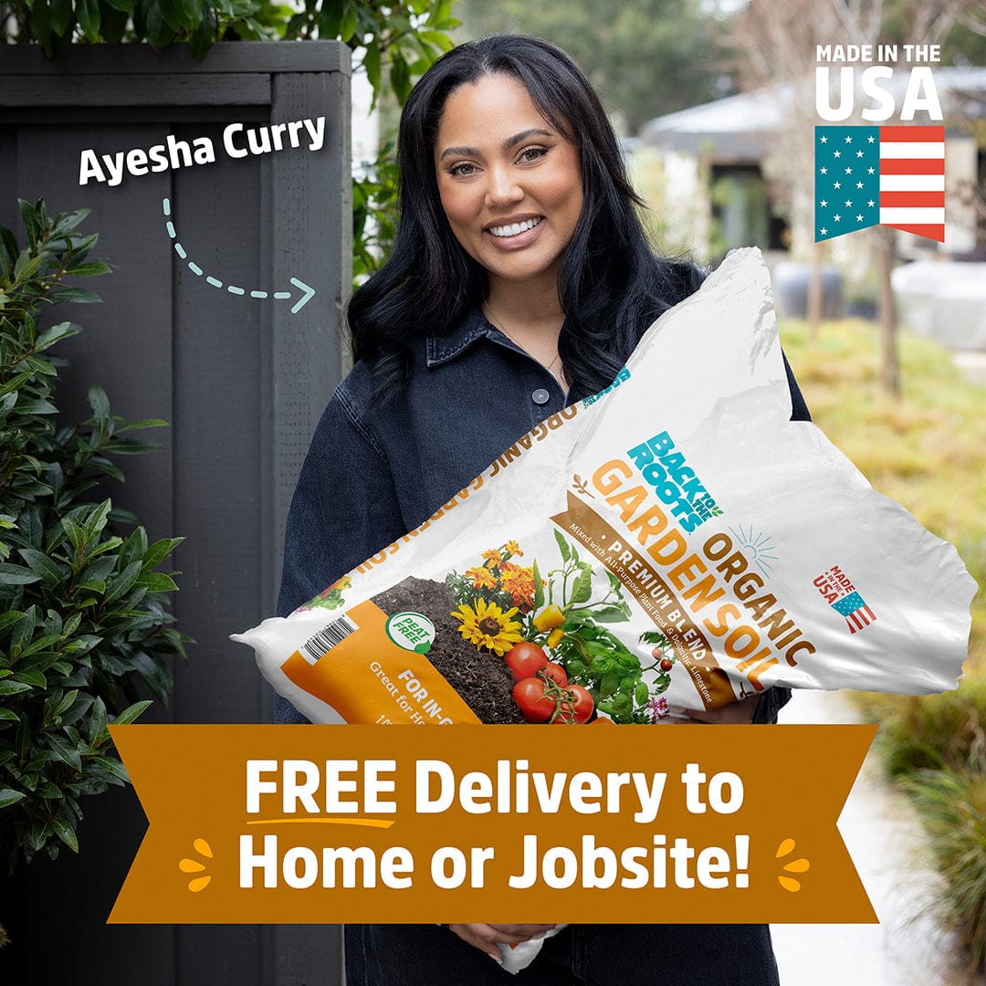 A woman holds a bag of Back to the Roots Organic Premium Blend Garden Soil 1 cu.ft.; text says "FREE Delivery to Home or Jobsite!" and "Made in the USA." Ayesha Curry is featured, highlighting its healthy, sustainable formula.