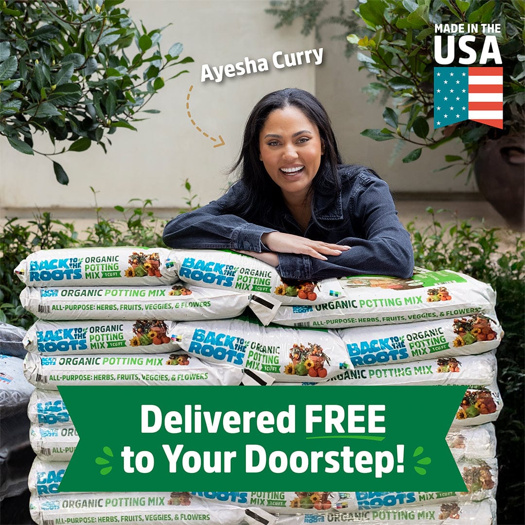 Ayesha Curry leans on stacked Back to the Roots Organic Bulk Potting Mix (60 1 cu. ft. Bags), labeled “Made in the USA” and “Delivered FREE to Your Doorstep!”—a 100% peat-free soil for your garden needs.