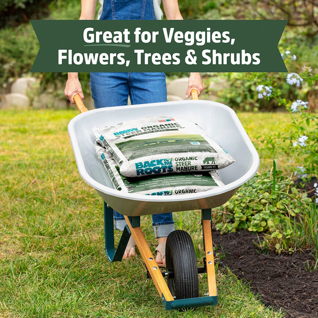 White wheelbarrow holding two stacked white bags of organic steer manure with green and black text outdoors near garden. - Organic Bulk Steer Manure (30 1 cu.ft. Bags) - Default Title - Back to the Roots