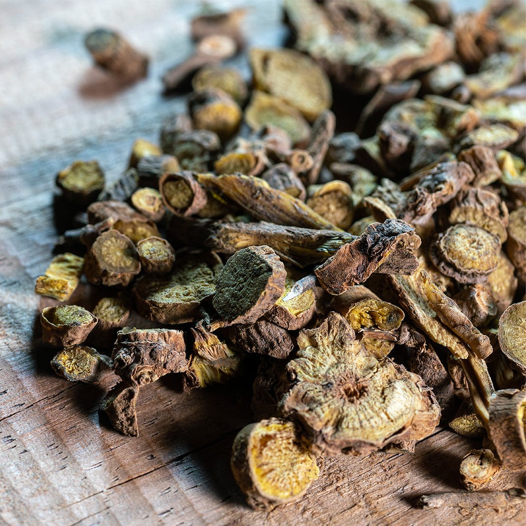 Dried organic Chinese skullcap seeds in irregular round and sliced shapes with earthy brown and yellow tones on a wooden. - Organic Chinese Skullcap Seeds ROC - Default Title - Back to the Roots