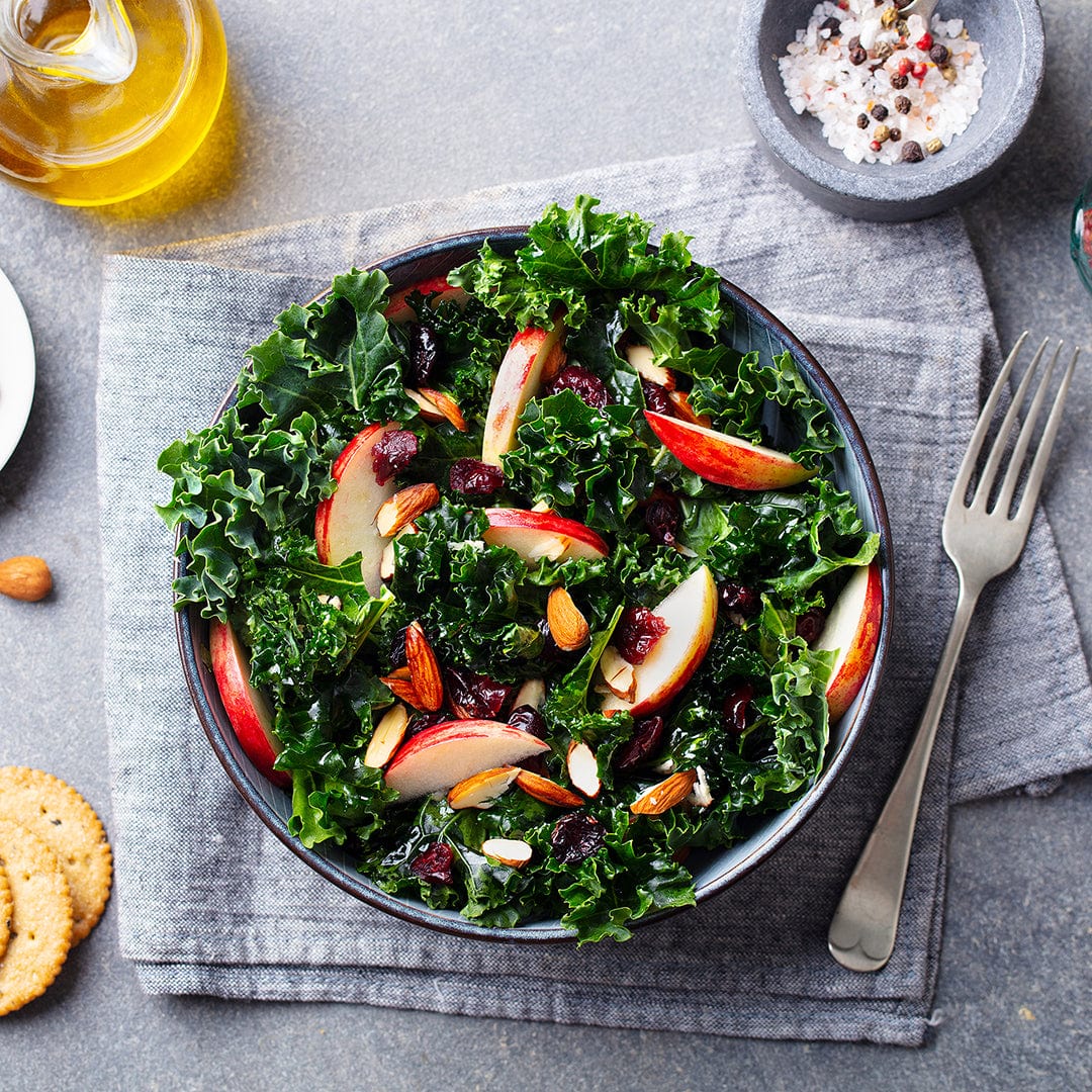 Bowl of fresh kale salad with apple slices, pomegranate seeds, almonds, and balsamic dressing on gray cloth napkin. - Winter Veggies Organic Seed Bundle - Default Title - Back to the Roots