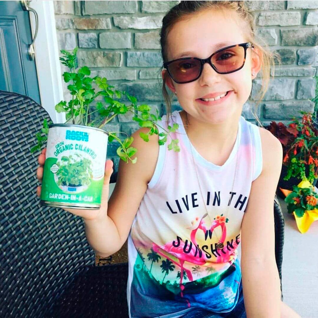Young girl holding a can with lush green cilantro, smiling, wearing sunglasses and a colorful tank top. - 6 Pack of Pre-Grown Cilantro, Dill, Oregano Live Seedlings - Default Title - Back to the Roots